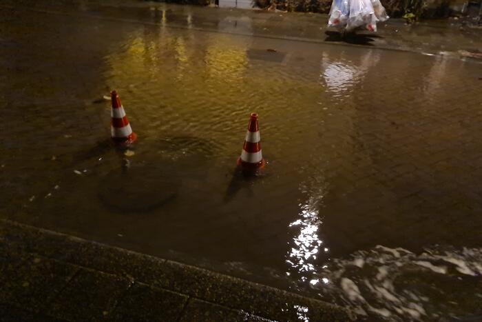 Straat onderwater door gesprongen hoofdwaterleiding