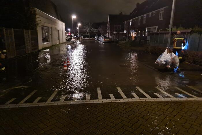 Straat onderwater door gesprongen hoofdwaterleiding