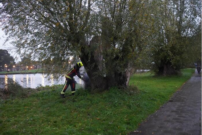 Brandweer blust brand in boom met emmer