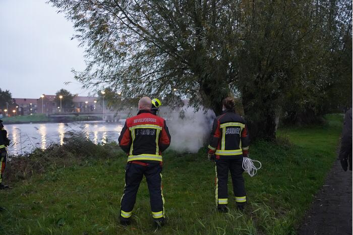 Brandweer blust brand in boom met emmer