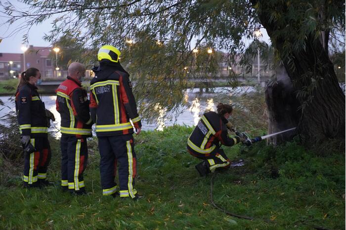 Brandweer blust brand in boom met emmer