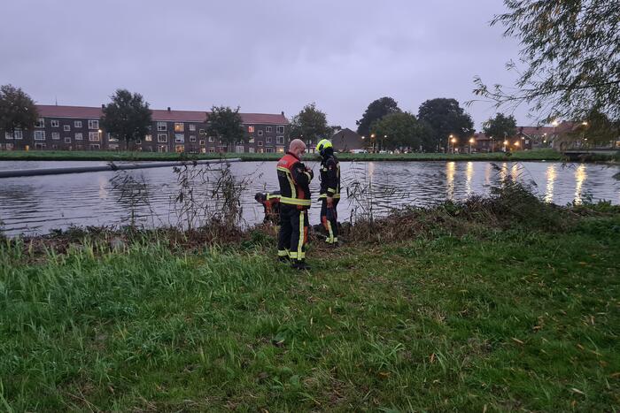 Brandweer blust brand in boom met emmer