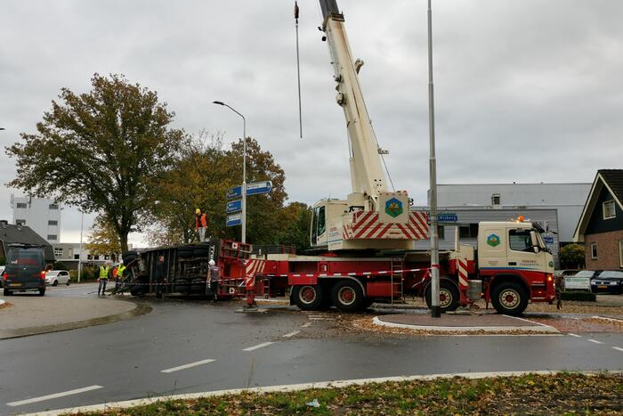 Grote aanhanger met verreiker op z'n kant op rotonde