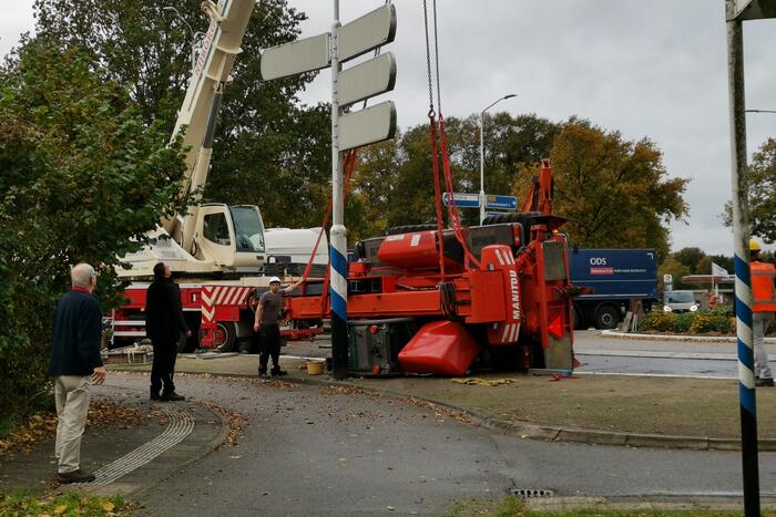Grote aanhanger met verreiker op z'n kant op rotonde