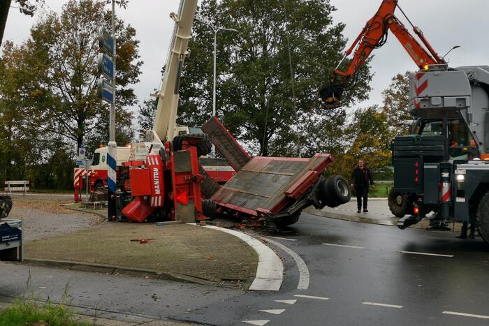 Grote aanhanger met verreiker op z'n kant op rotonde