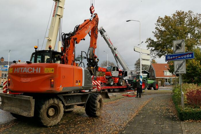 Grote aanhanger met verreiker op z'n kant op rotonde