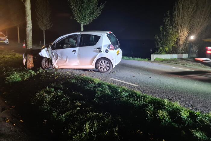 Auto rijdt tegen lantaarnpaal en komt tot stilstand tegen boom