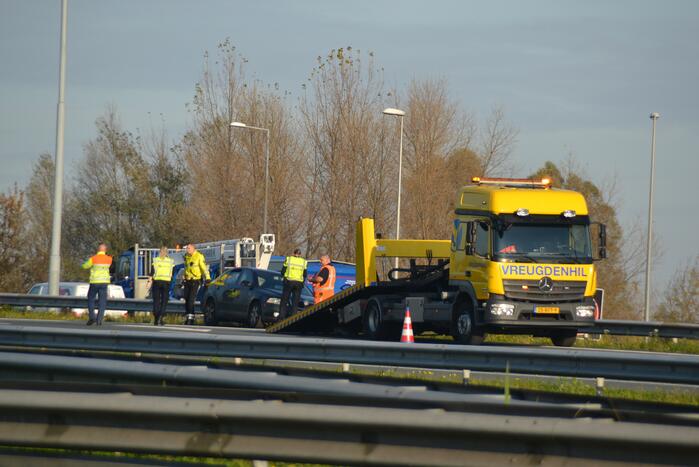 Personenauto heeft schade na botsing tegen vangrail