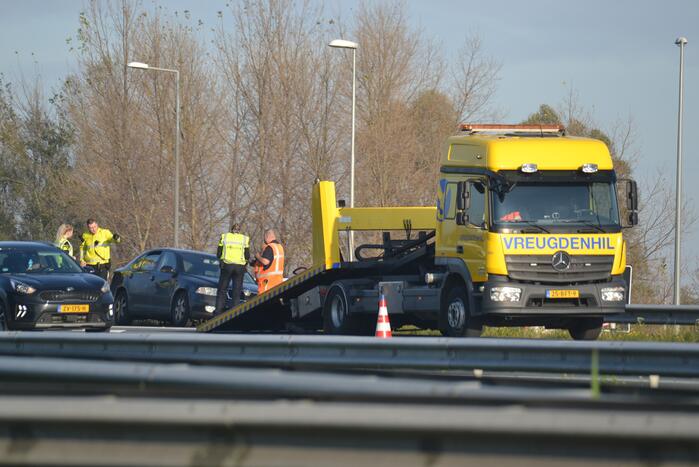 Personenauto heeft schade na botsing tegen vangrail