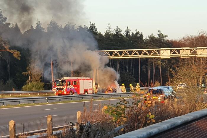 Brandweer blust brand in personenauto op snelweg