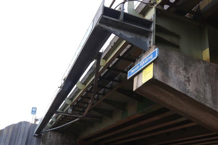 Vrachtwagen met graafmachine ramt spoorbrug