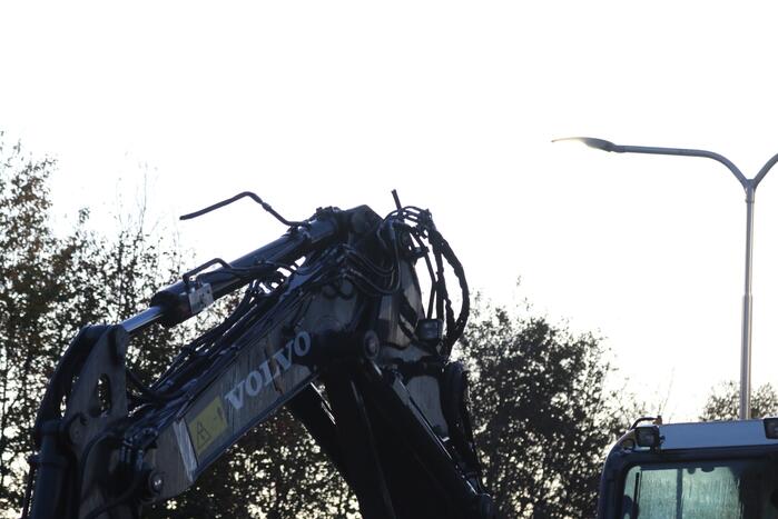 Vrachtwagen met graafmachine ramt spoorbrug