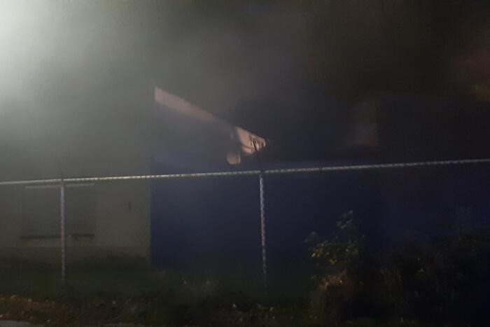 Berg afval in brand achter schoolgebouw
