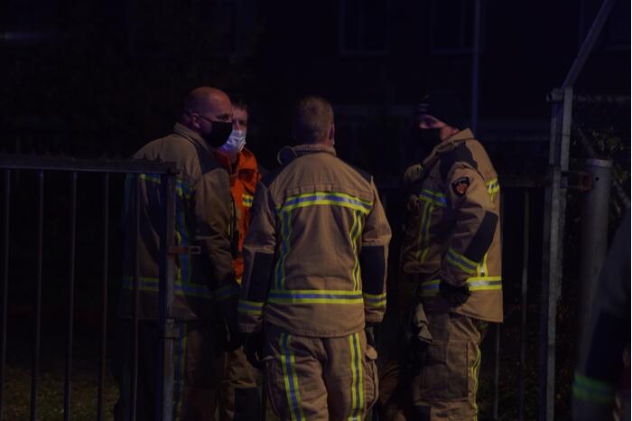 Berg afval in brand achter schoolgebouw