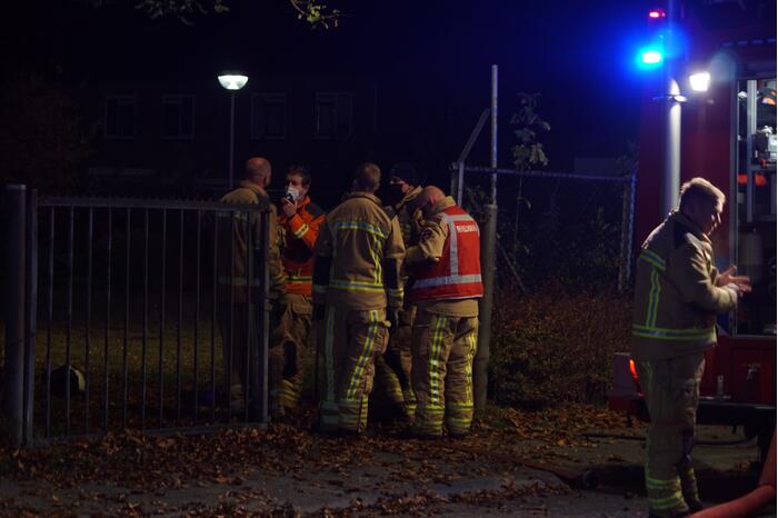 Berg afval in brand achter schoolgebouw