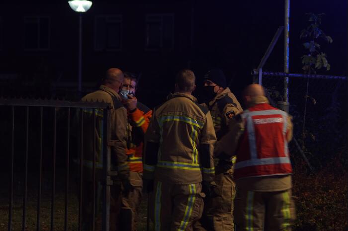 Berg afval in brand achter schoolgebouw