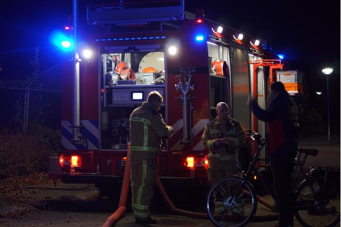 Berg afval in brand achter schoolgebouw