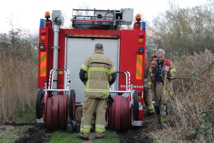 Brandweerwagen rijdt zich vast in modder in natuurgebied
