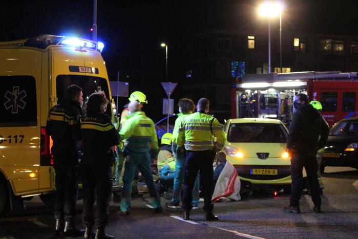 Fietser bekneld onder auto