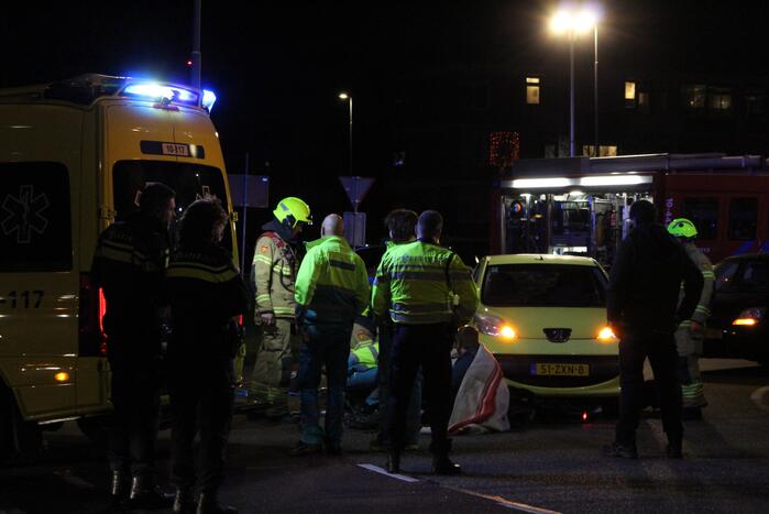 Fietser bekneld onder auto