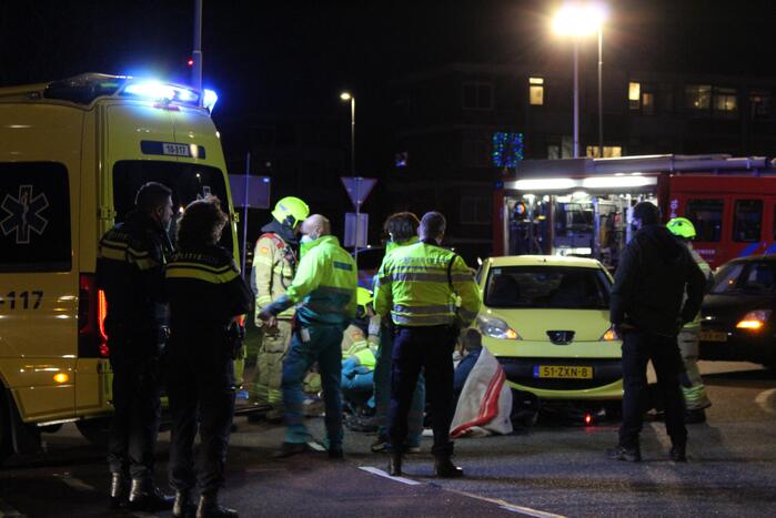 Fietser bekneld onder auto