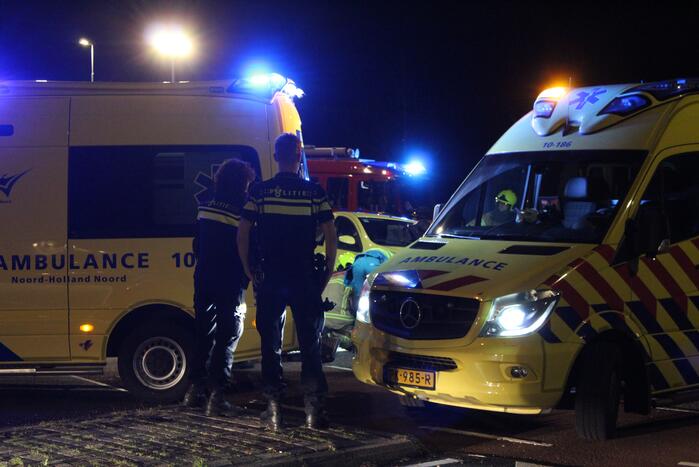 Fietser bekneld onder auto