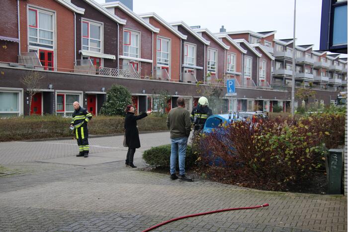 Omstanders blussen brand in papiercontainer