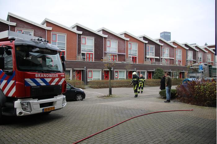 Omstanders blussen brand in papiercontainer