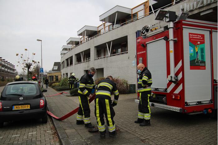 Omstanders blussen brand in papiercontainer