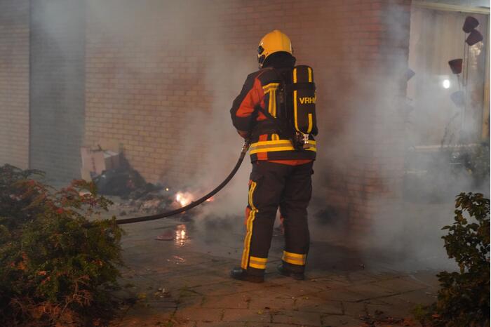 Oud papier tegen woning in brand gestoken