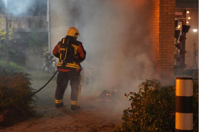 Oud papier tegen woning in brand gestoken