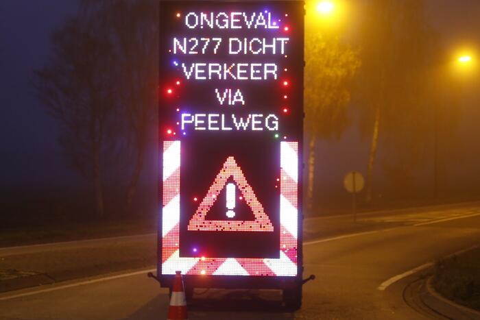 Vrachtwagen met aanhanger met hooi ramt boom