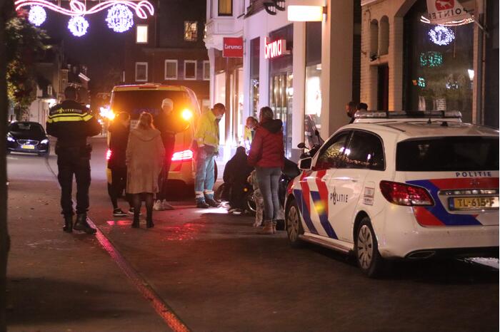 Scooter en fiets botsen in winkelgebied