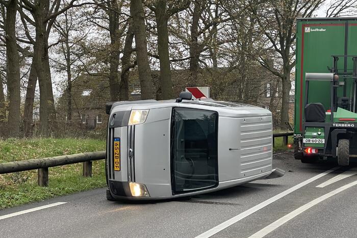Bestelbus belandt op zijn kant via vangrail