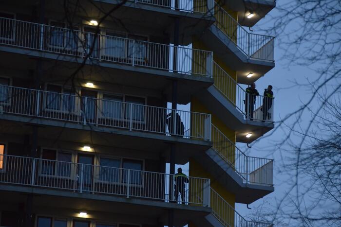 Verward persoon op galerij van flatwoning