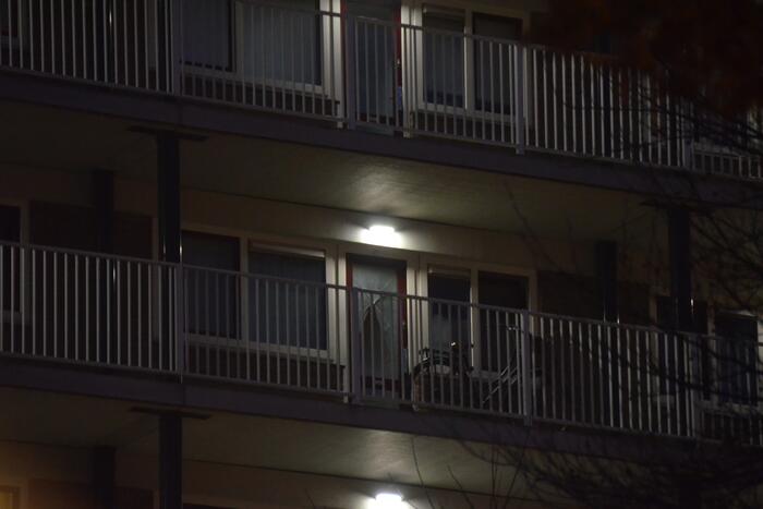 Verward persoon op galerij van flatwoning