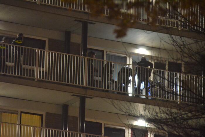 Verward persoon op galerij van flatwoning