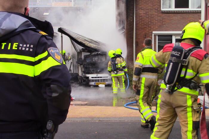 Camper naast woning gaat in vlammen op