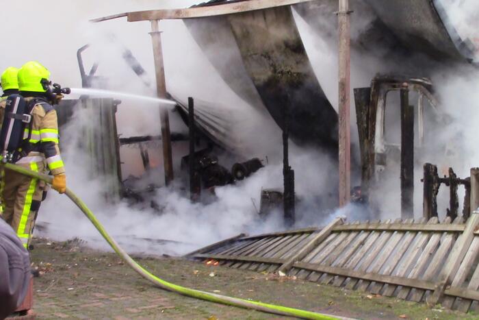 Camper naast woning gaat in vlammen op