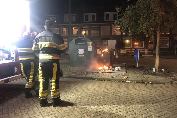 Papier in brand naast container