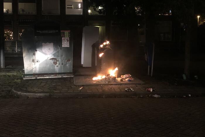 Papier in brand naast container