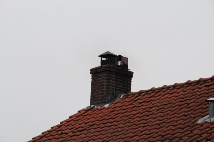 Brandweer blust brand in schoorsteen