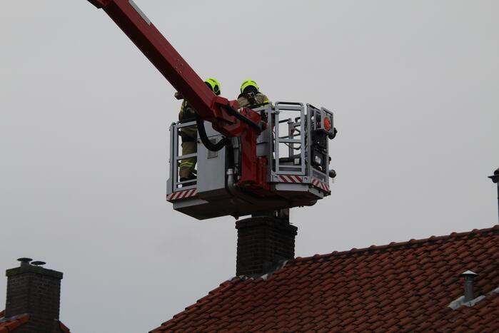 Brandweer blust brand in schoorsteen