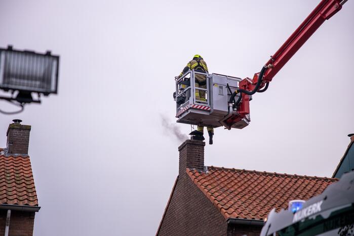 Brandweer blust brand in schoorsteen
