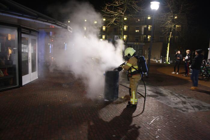 Brandweer blust twee brandende prullenbakken