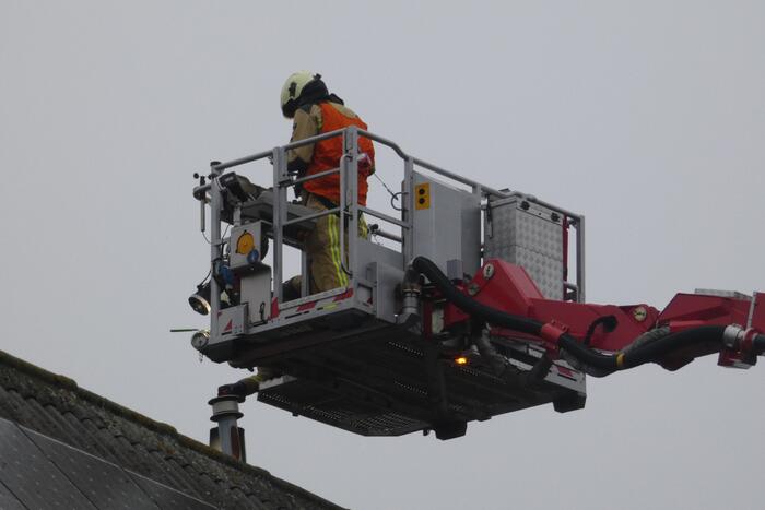 Brandweer blust brand in schoorsteen