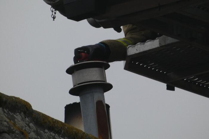 Brandweer blust brand in schoorsteen