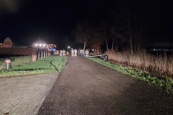 Auto vliegt uit de bocht en belandt op zijn kant in sloot