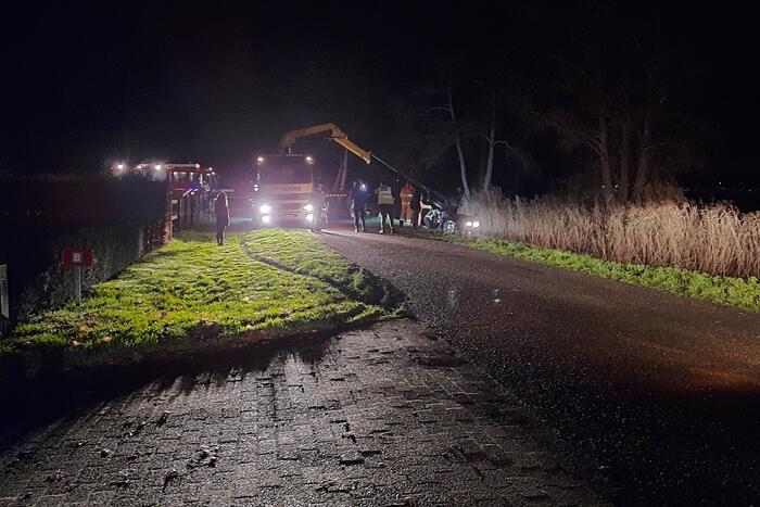 Auto vliegt uit de bocht en belandt op zijn kant in sloot