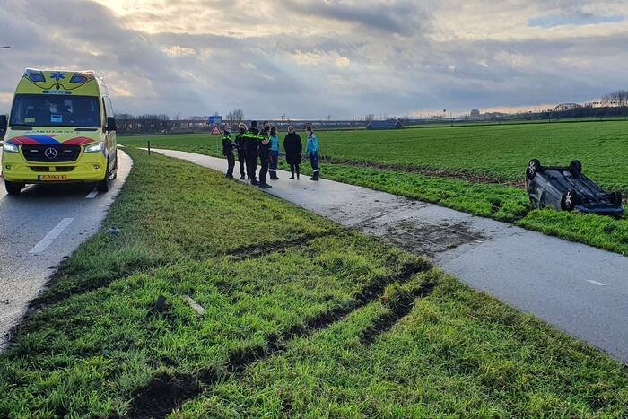 Personenauto raakt van de weg en belandt op zijn dak